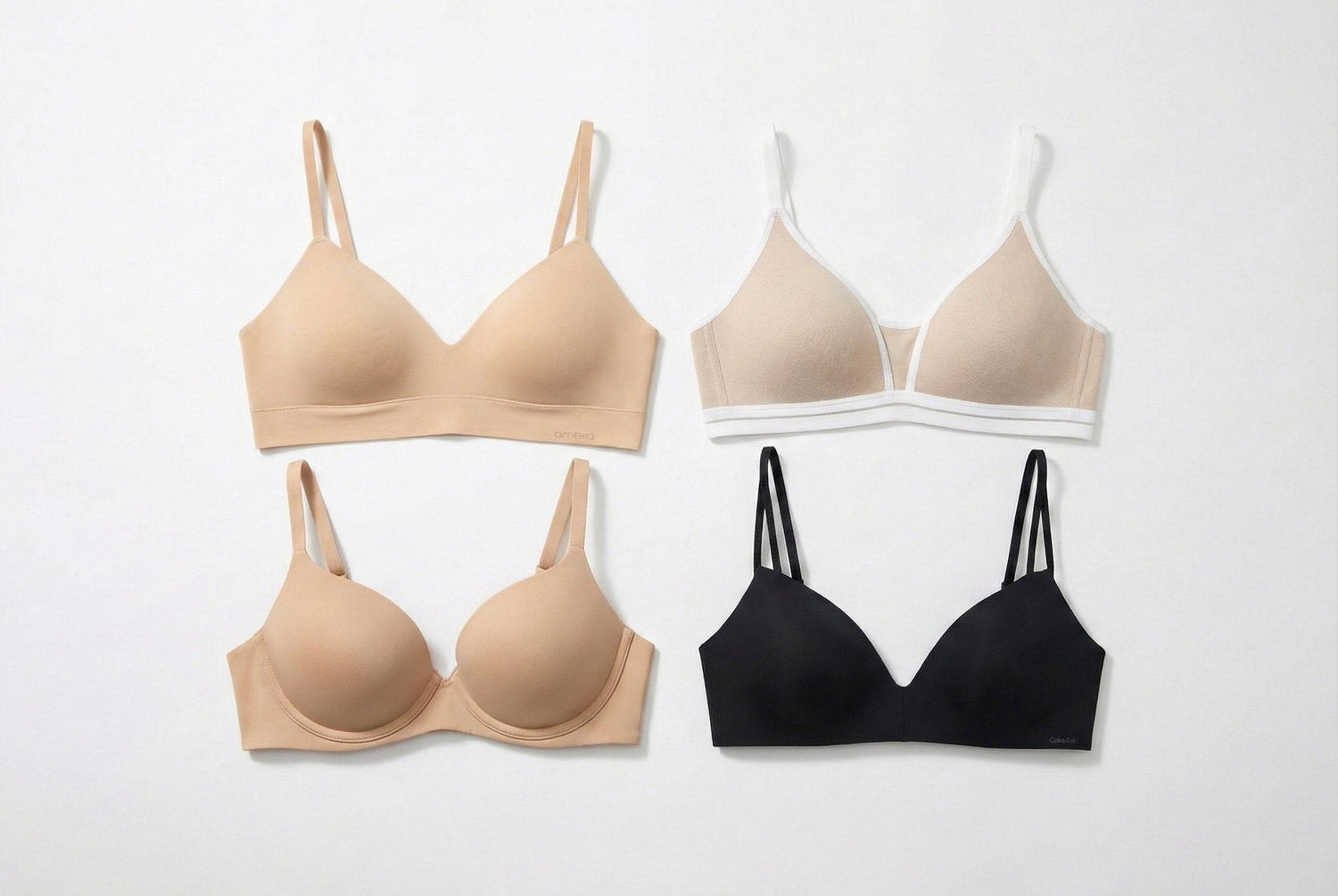Four minimalist wireless training bras in beige and black with smooth fabric and subtle trim details for teens