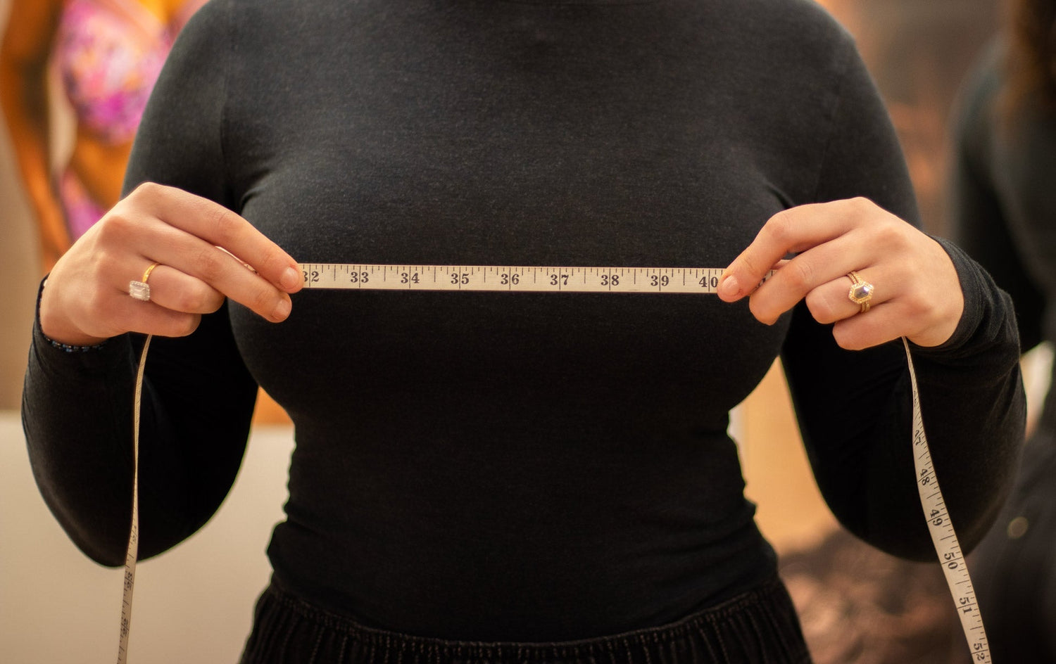 White measuring tape held taut across chest for bra size measurement