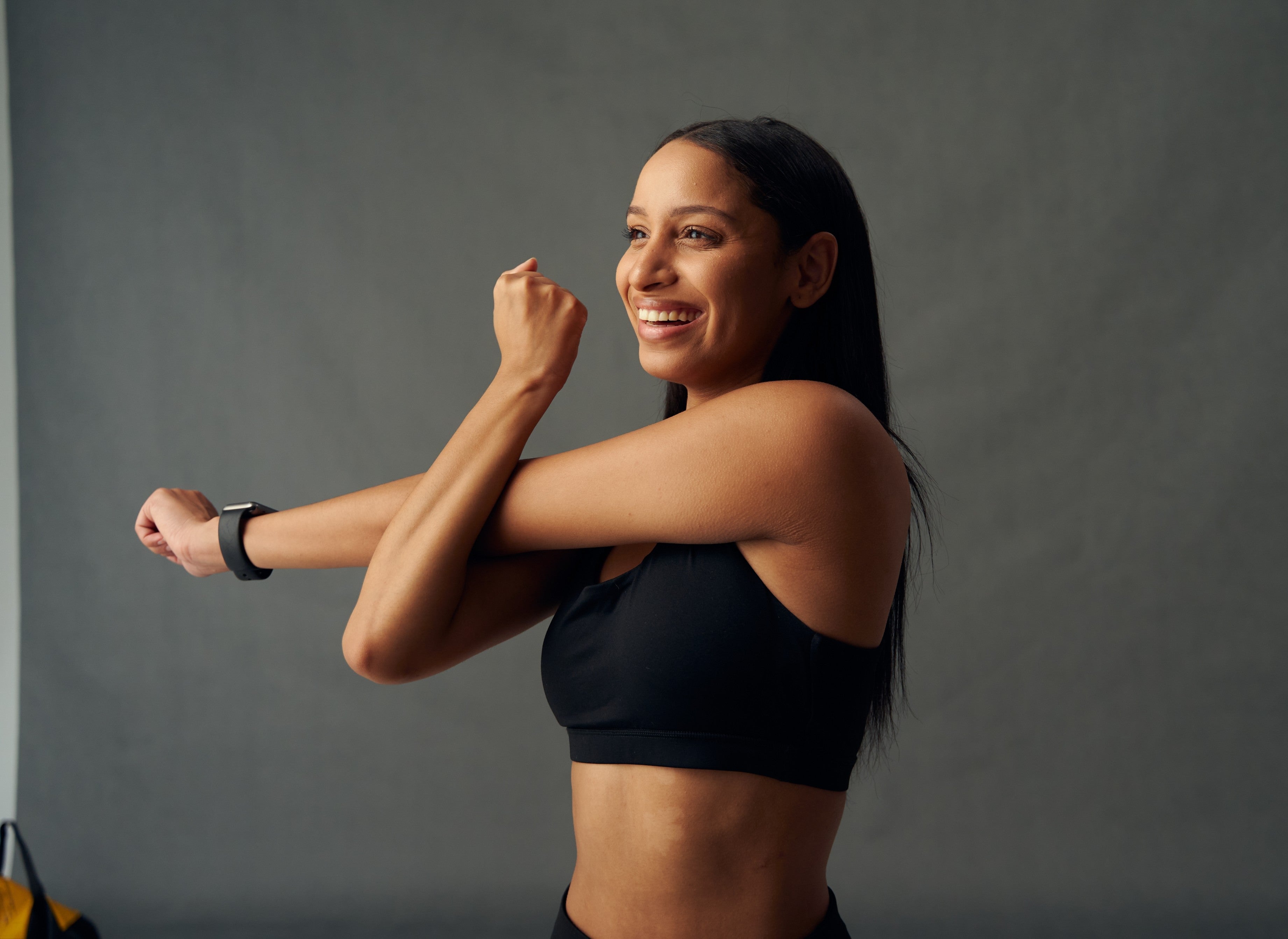 Black smartwatch with sleek minimalist design worn on woman’s left wrist featured in top 10 best sports bras article