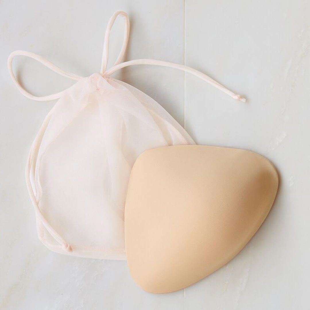 Beige silicone underwire-free bra cup with matching sheer drawstring pouch from amoena collection