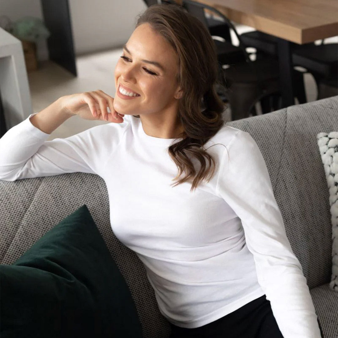 Woman sitting on couch in Baselayers thermal clothes
