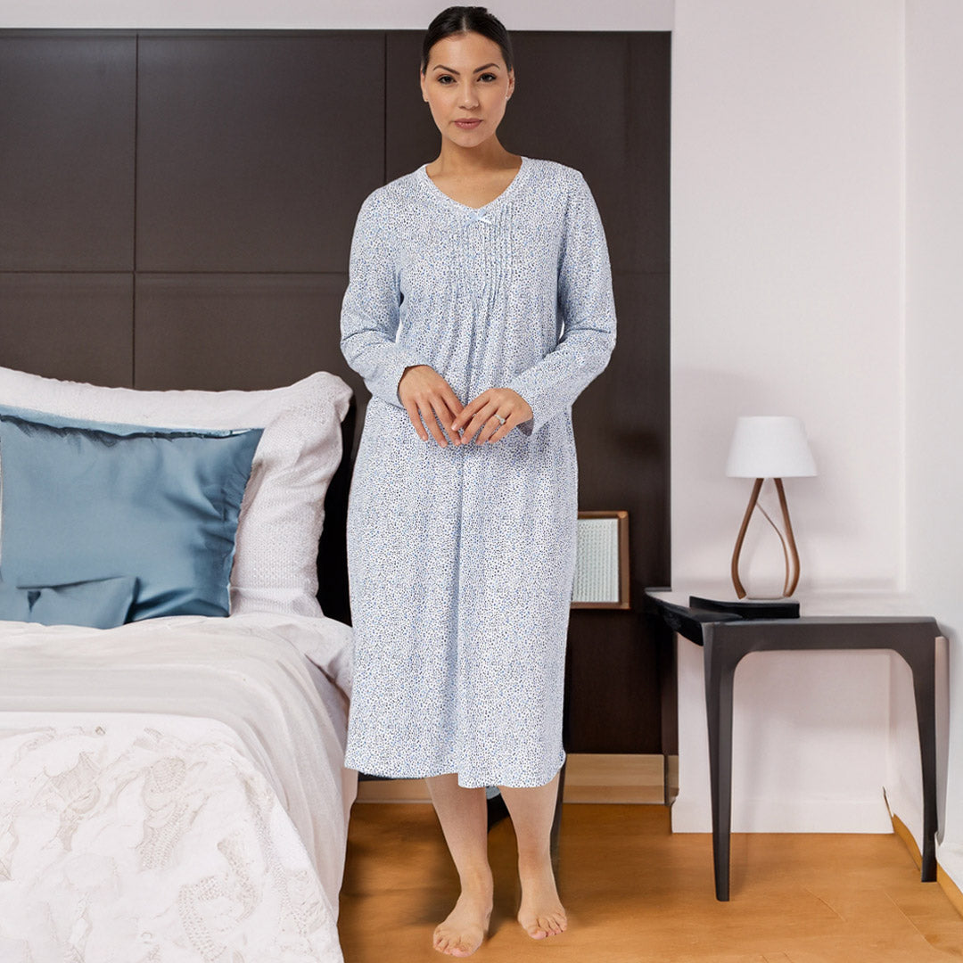 A woman wearing a light blue and white patterned long-sleeved nightgown with v-neckline from the Schrank collection