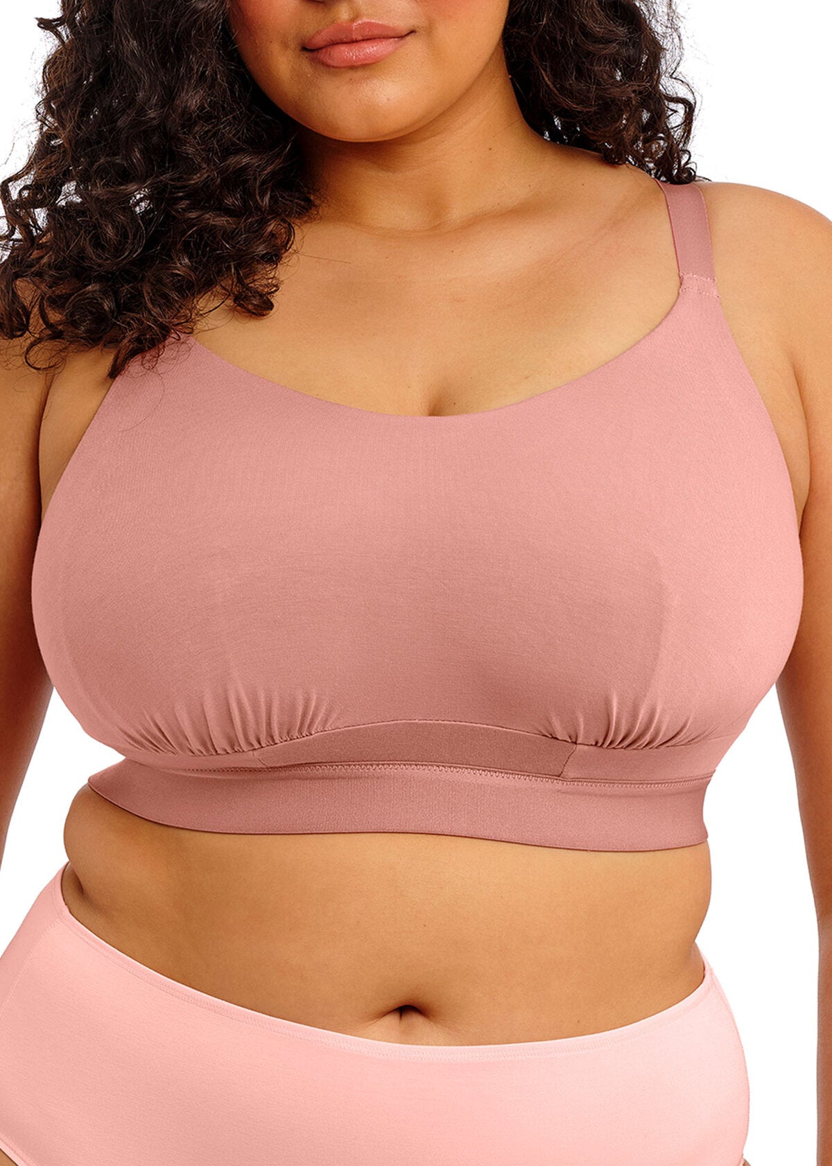 A soft blush pink downtime non wired bralette sports bra with adjustable straps and a ruched band