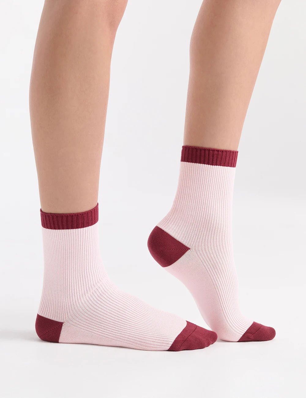Pink ribbed ankle socks with contrasting burgundy toe and heel accents.