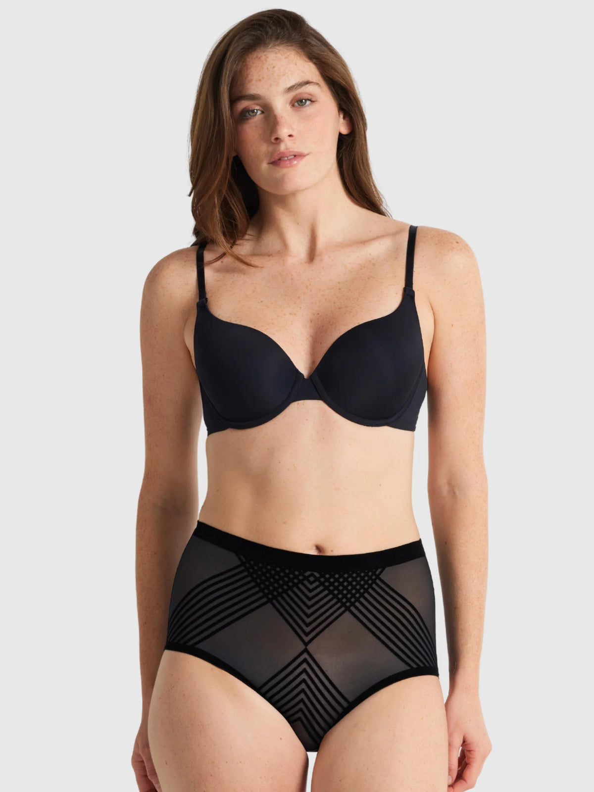 Black underwire bra with thin straps and smooth structured cups paired with sheer power waisted brief