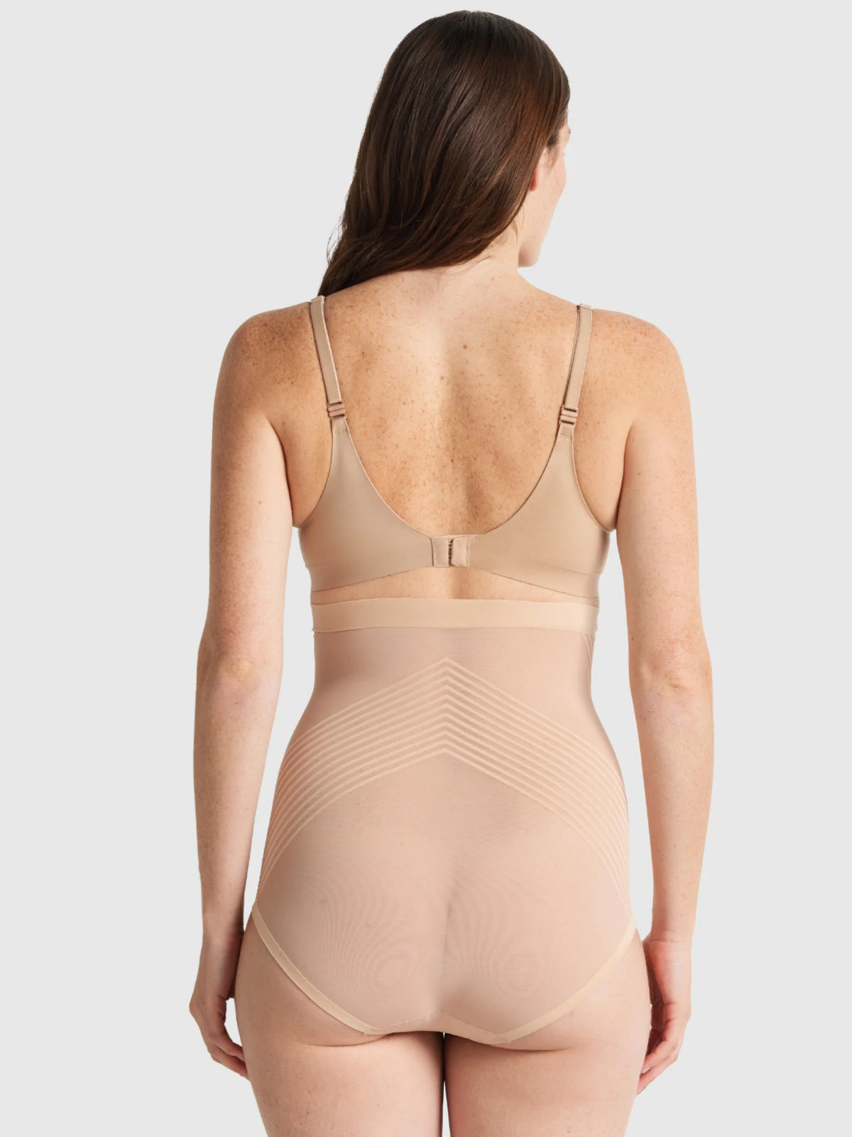 Beige seamless shapewear bodysuit with thin straps and supportive waistband from sheer power high waist brief collection