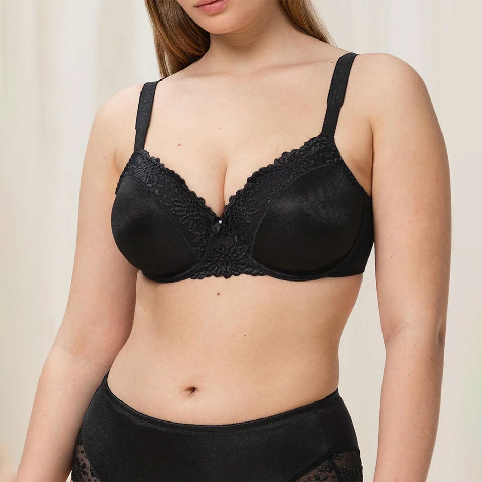 Woman wearing a black best selling bra on a cream background