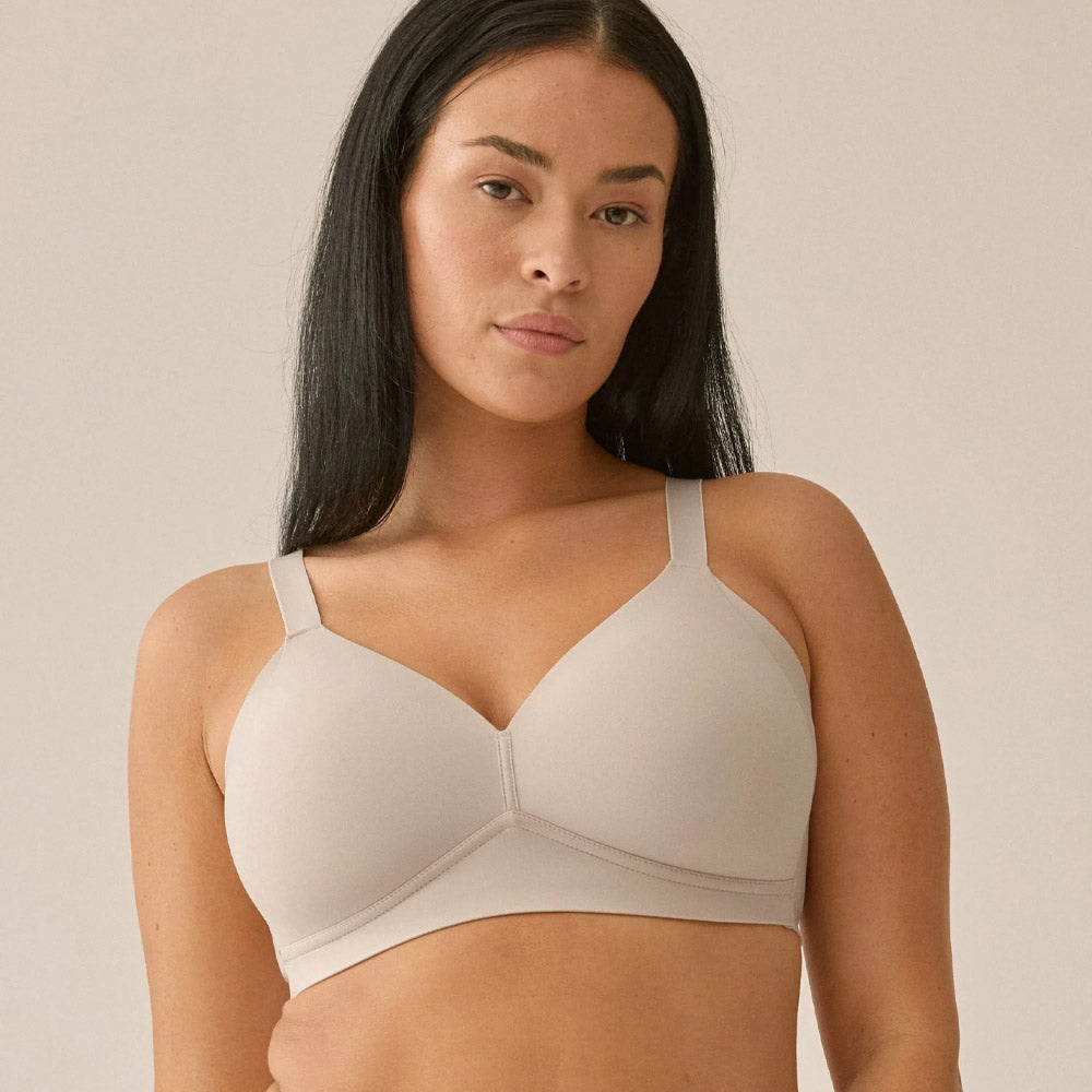 Woman wearing a beige bra against a plain background