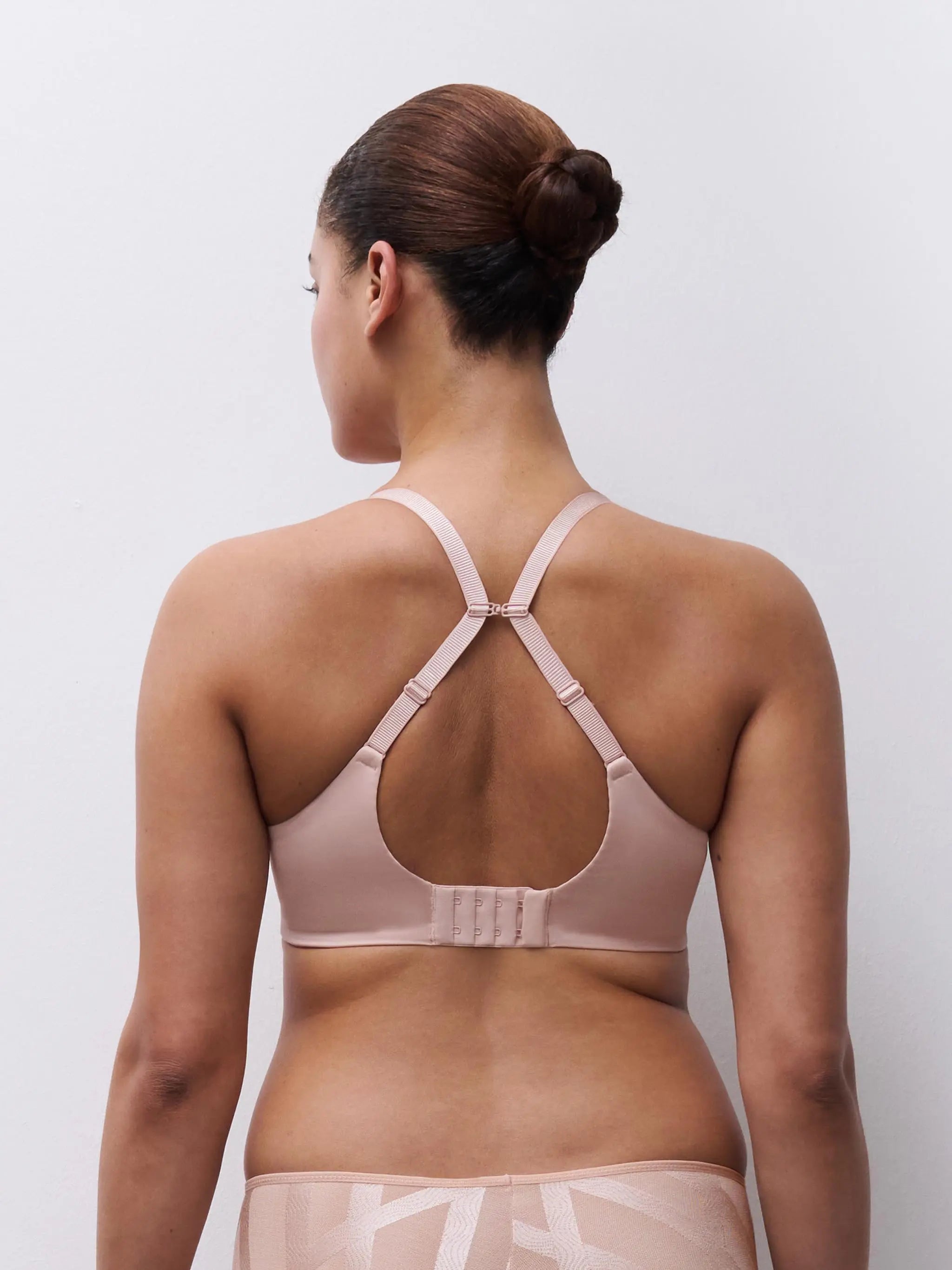 A soft blush pink Glaze Very Covering sports bra back with crossed adjustable straps and central clasp for support