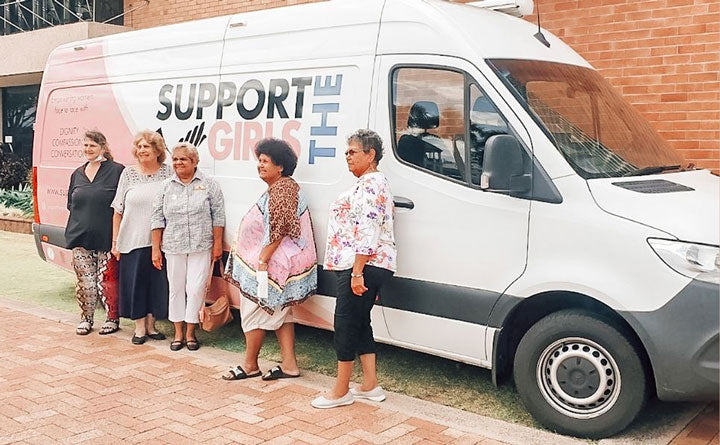 Women in front of support the girls van