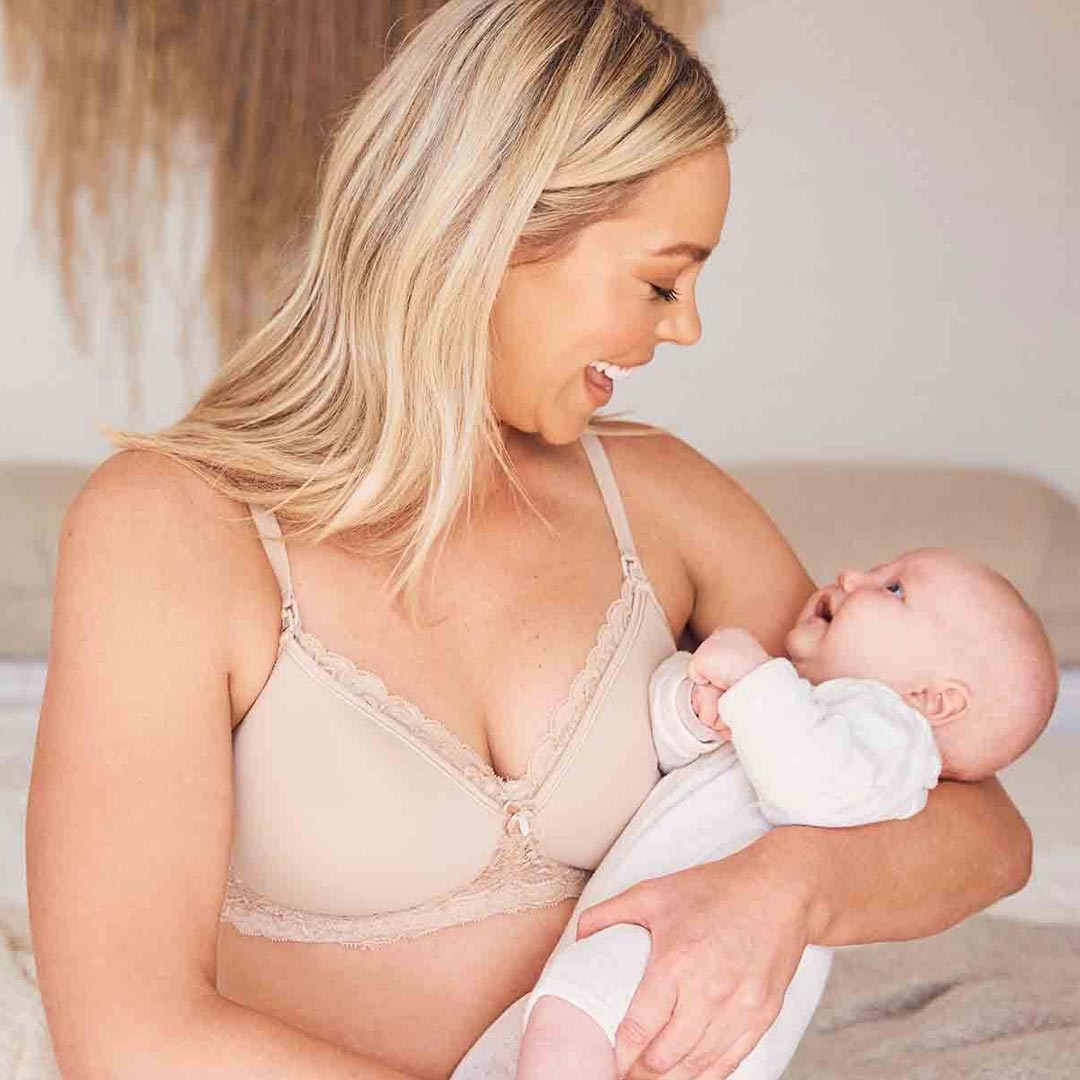 Woman in a Triumph maternity bra holding a baby
