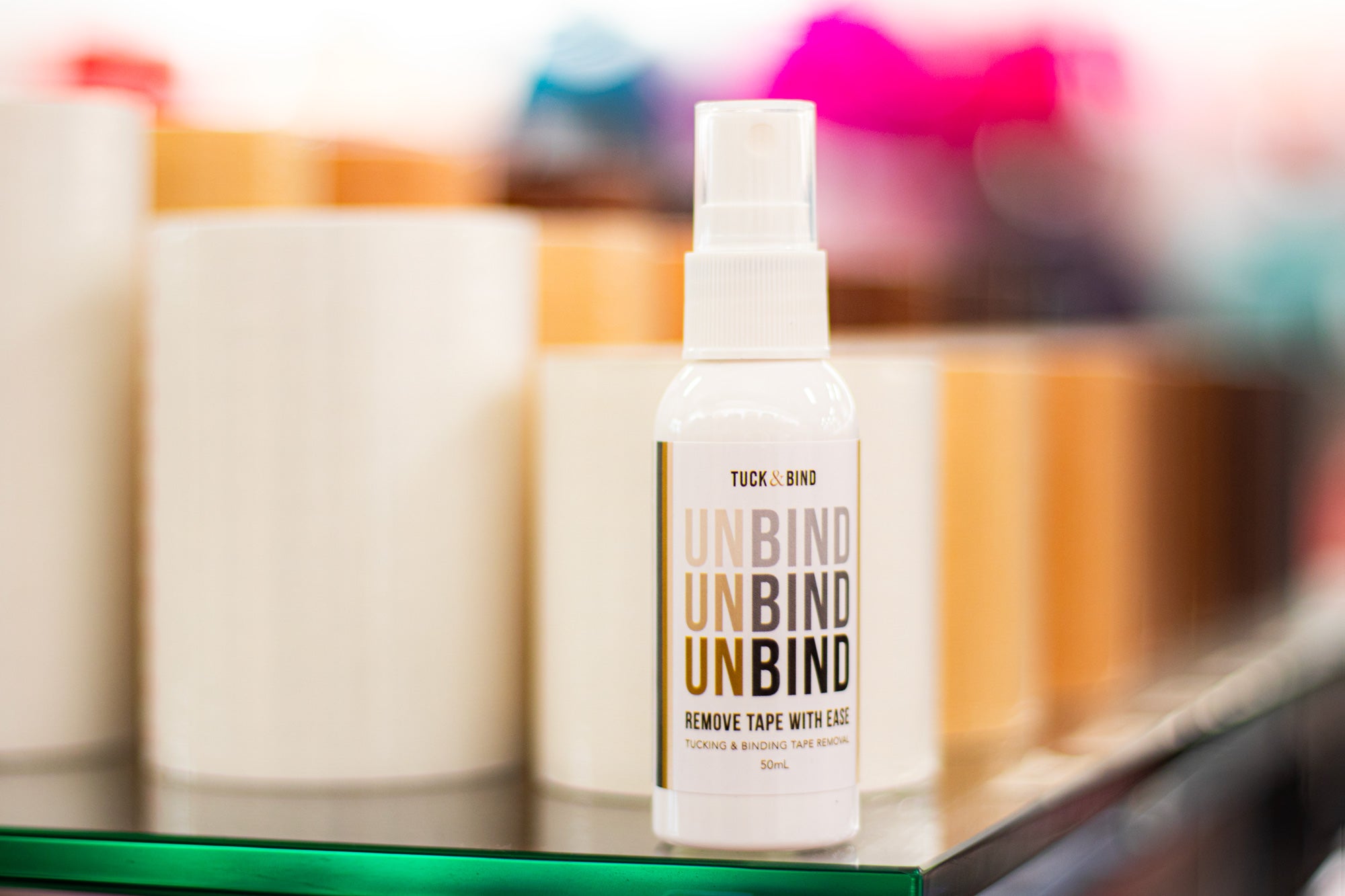 White Unbind spray bottle by Tuck & Bind for easy adhesive removal