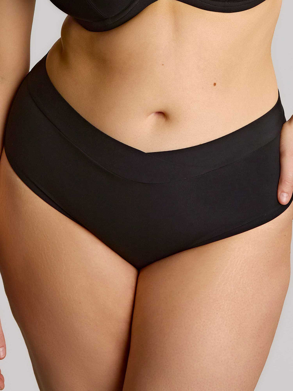 Black high-waisted seamless underwear with smooth design shown from the back in the body deep brief style