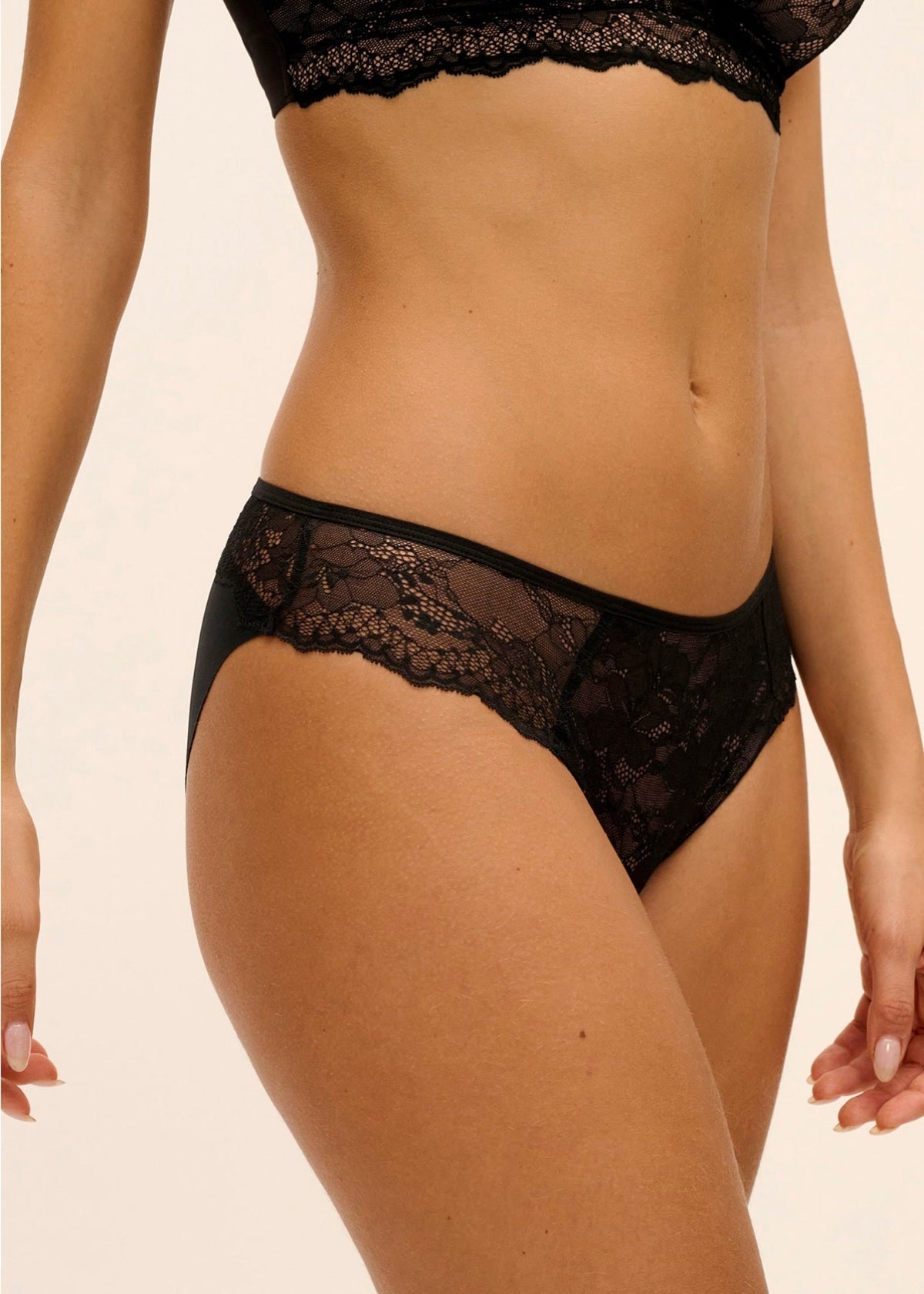Black lace Essence Brief bikini bottom with intricate floral patterns and seamless form-fitting design shown from the back