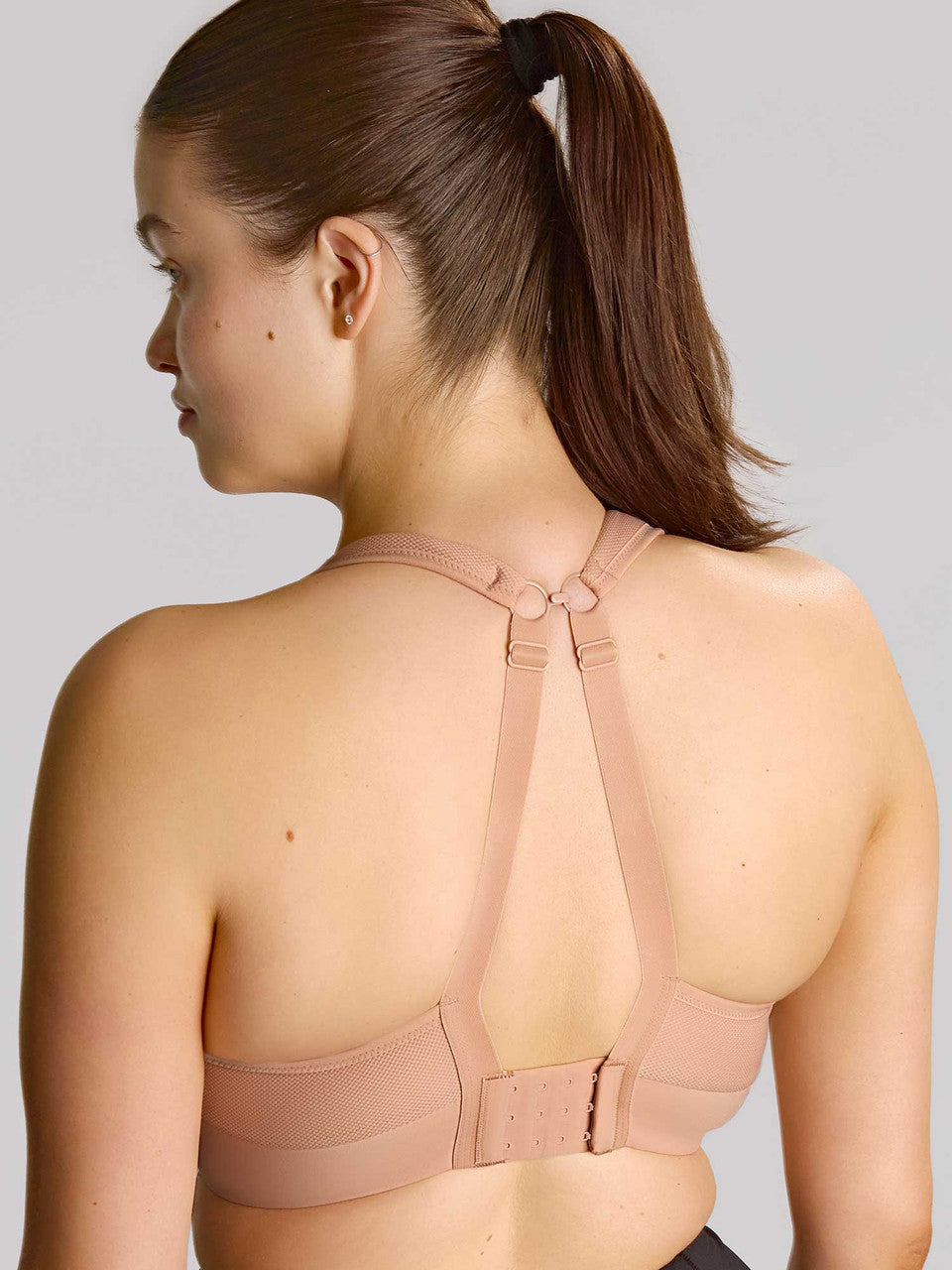 Thrive wired sports bra in nude color with seamless fabric, supportive back strap, and adjustable side straps shown from back