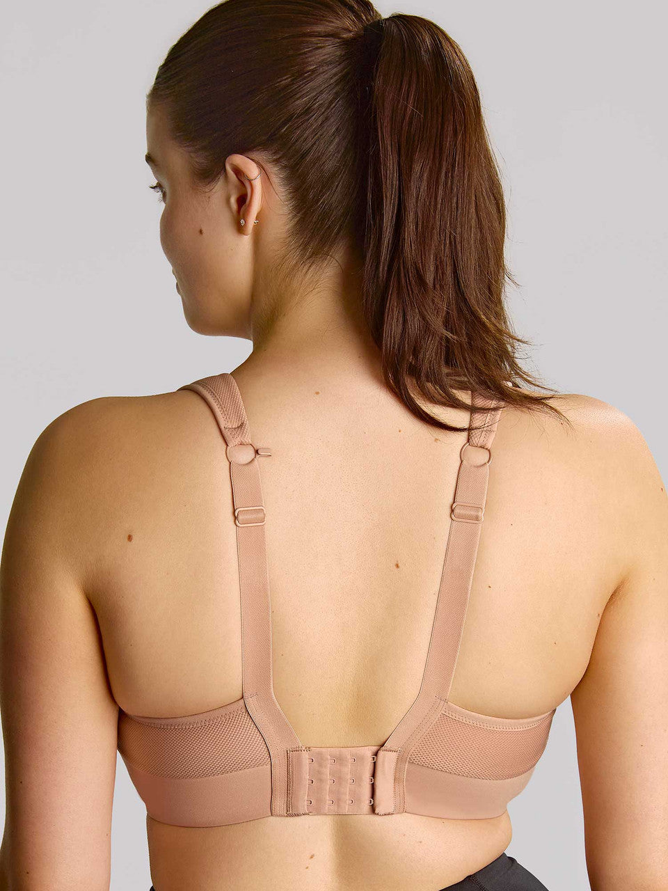 Beige thrive wired sports bra with adjustable straps and breathable mesh panel designed for active support