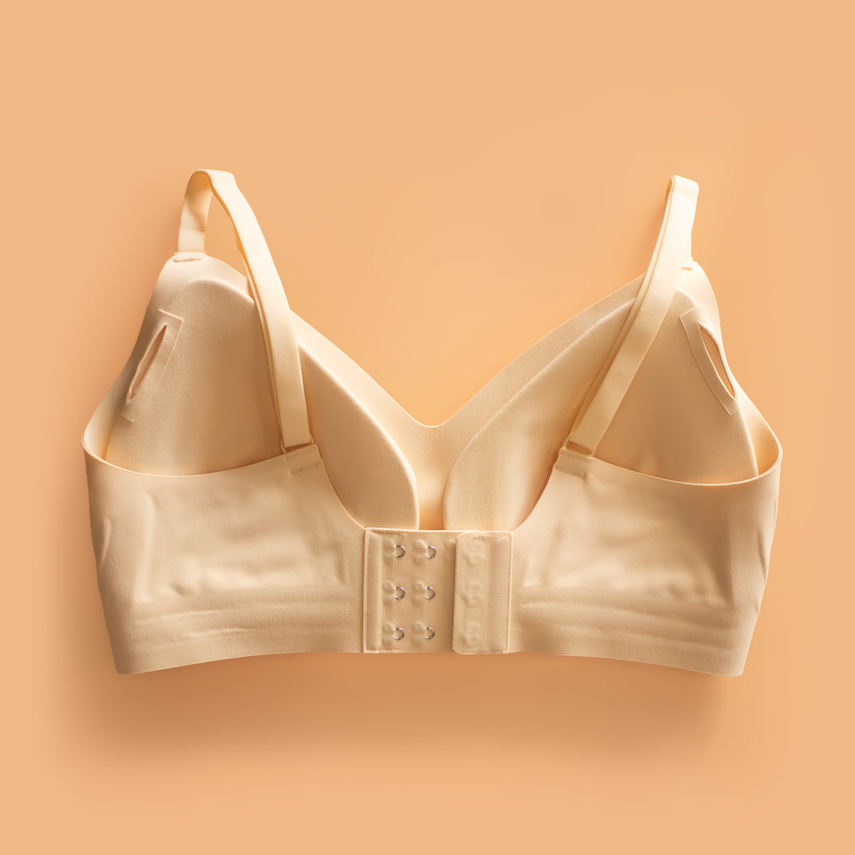 Beige satin Ava seamless shaping bra with underwire, adjustable straps, and front clasp closure for comfortable support