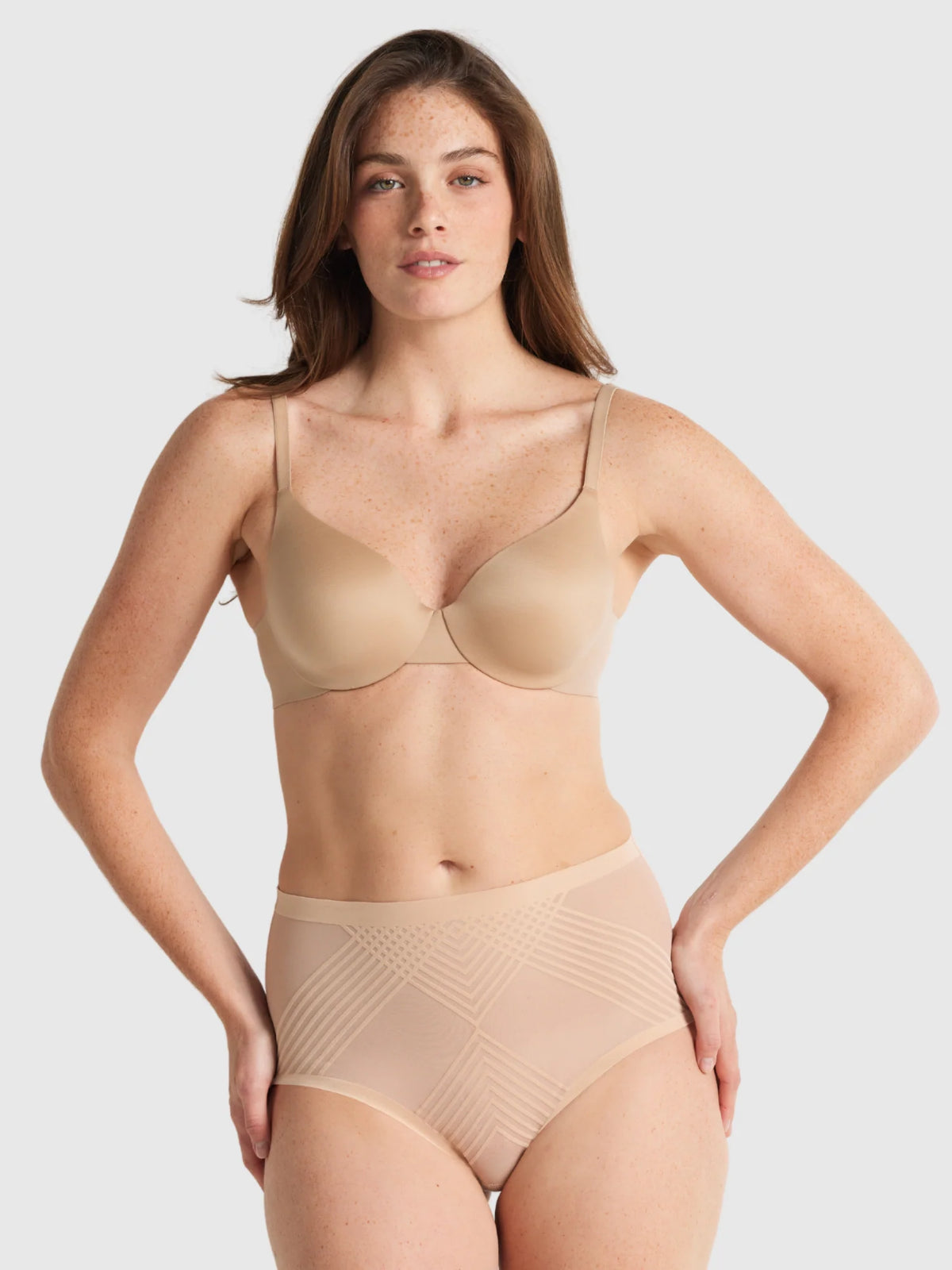 Beige seamless underwire bra with thin straps and sheer power waisted brief with subtle geometric pattern