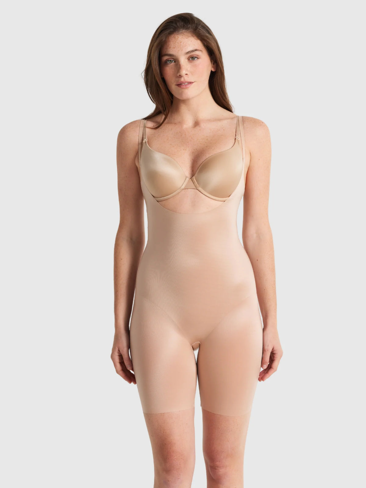 Beige seamless bodycon shapewear bodysuit with thin straps and smooth form-fitting design by body skiins underbust jumpsuit