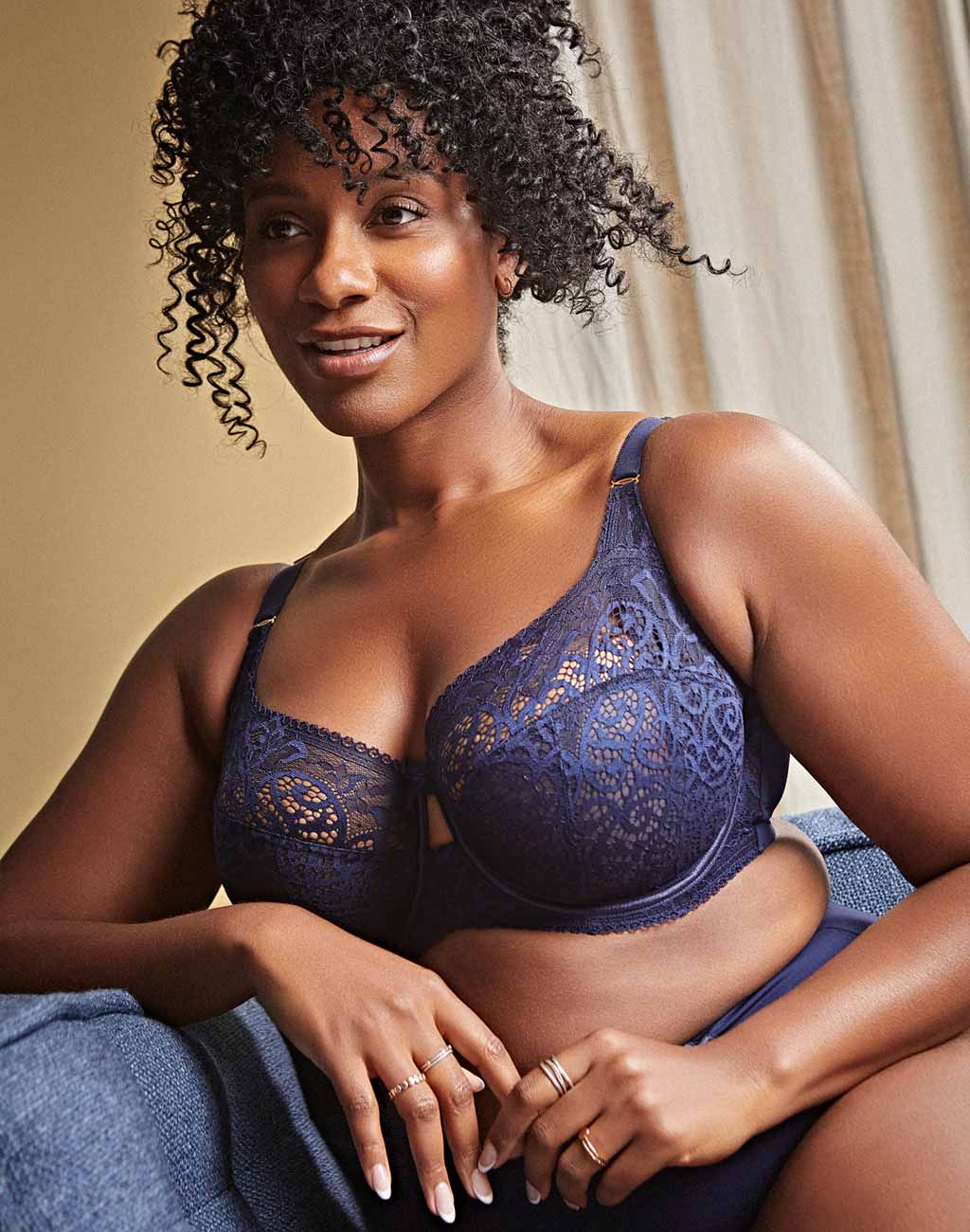 Woman sitting on couch in plus size bra