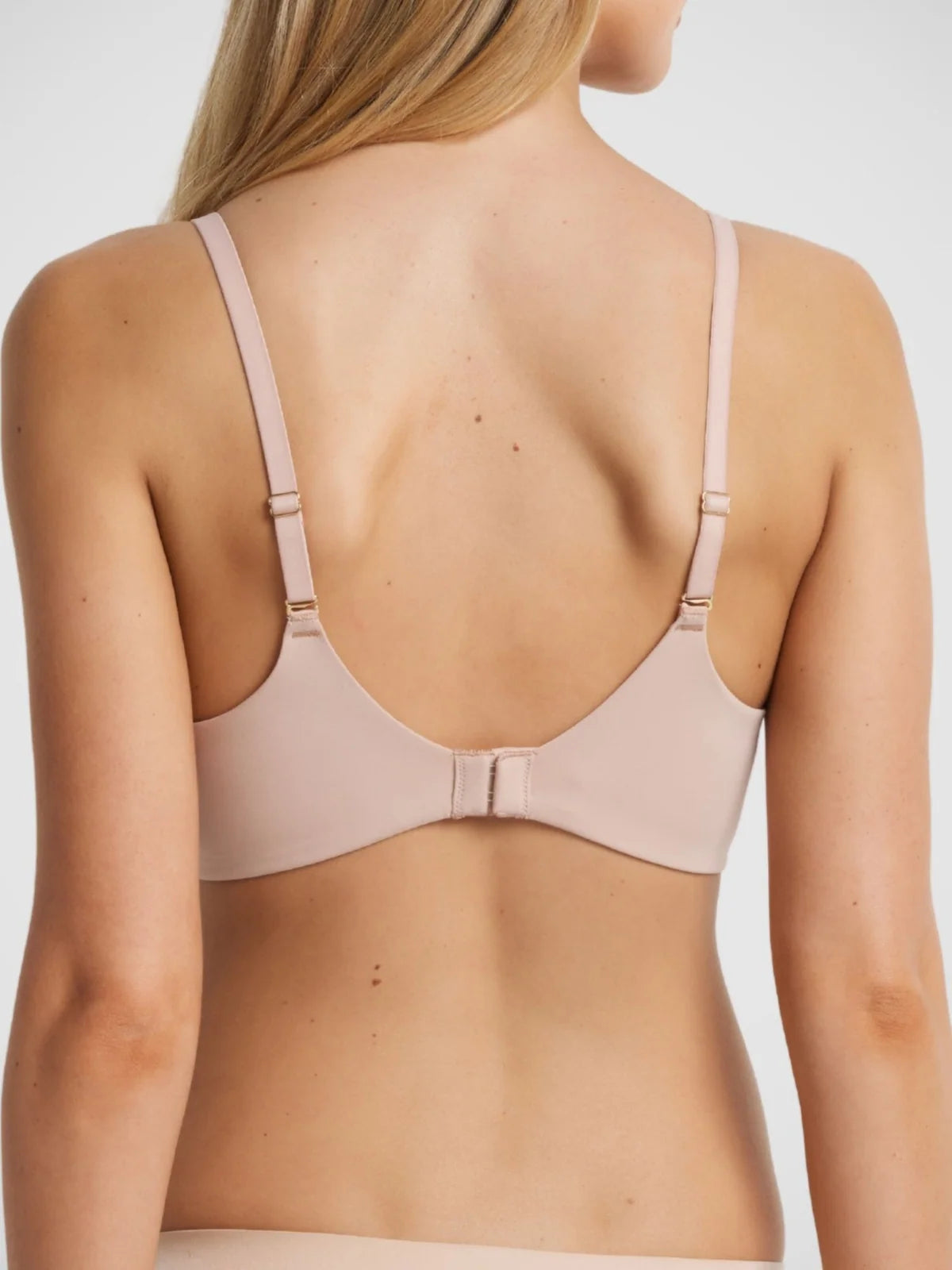 Memory t shirt bra in soft blush pink with underwire, delicate adjustable straps, and sleek back closure shown from the back