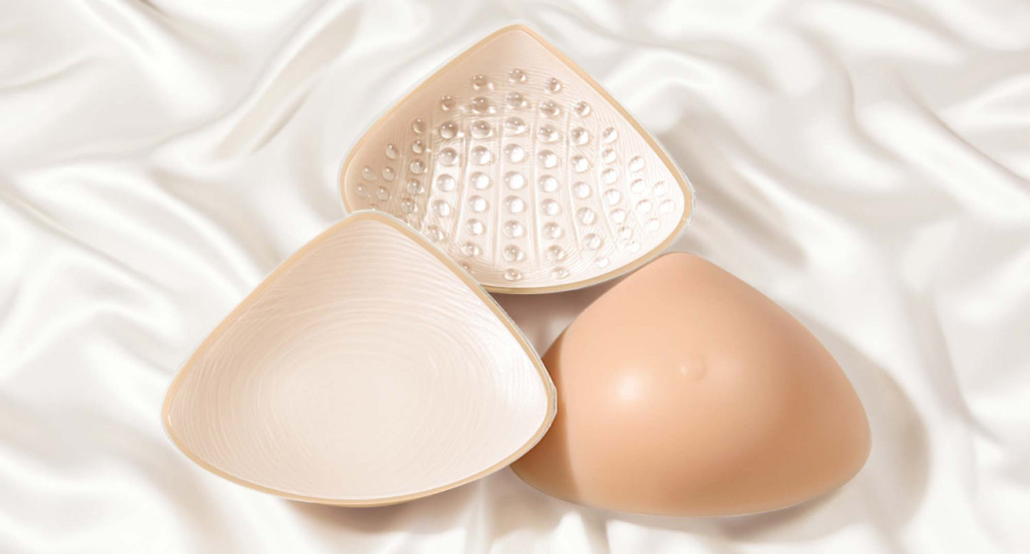 3 beige breast prosthesis on an ivory silk fabric background