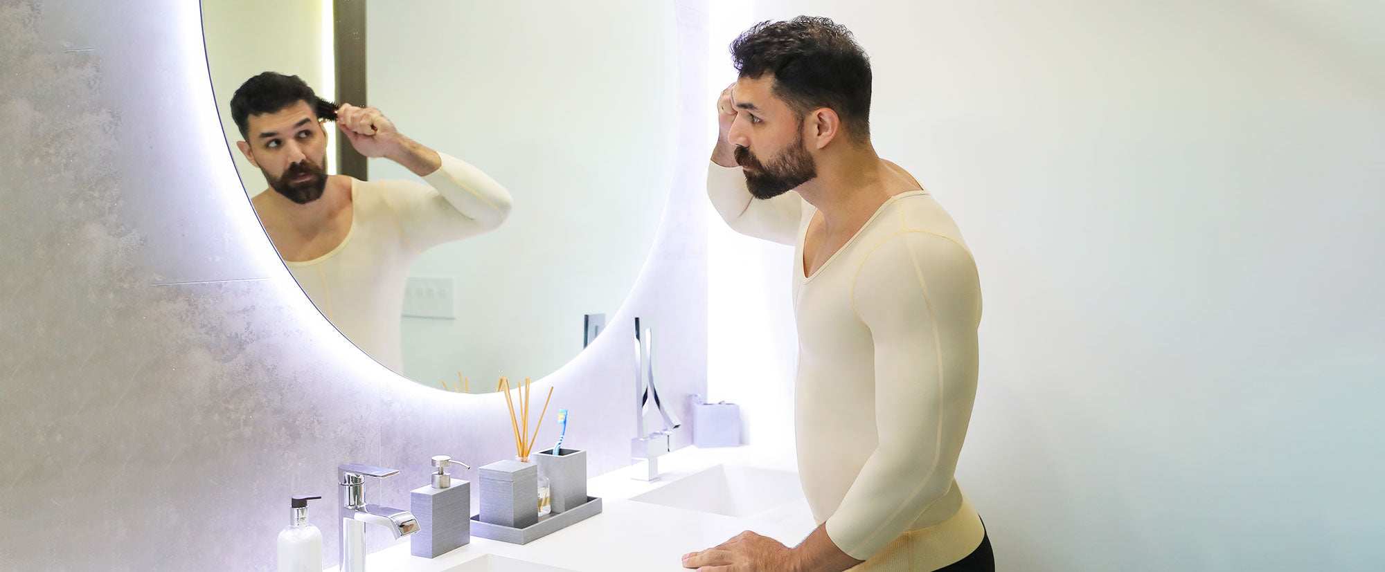 Man in compression garment combing hair in mirror
