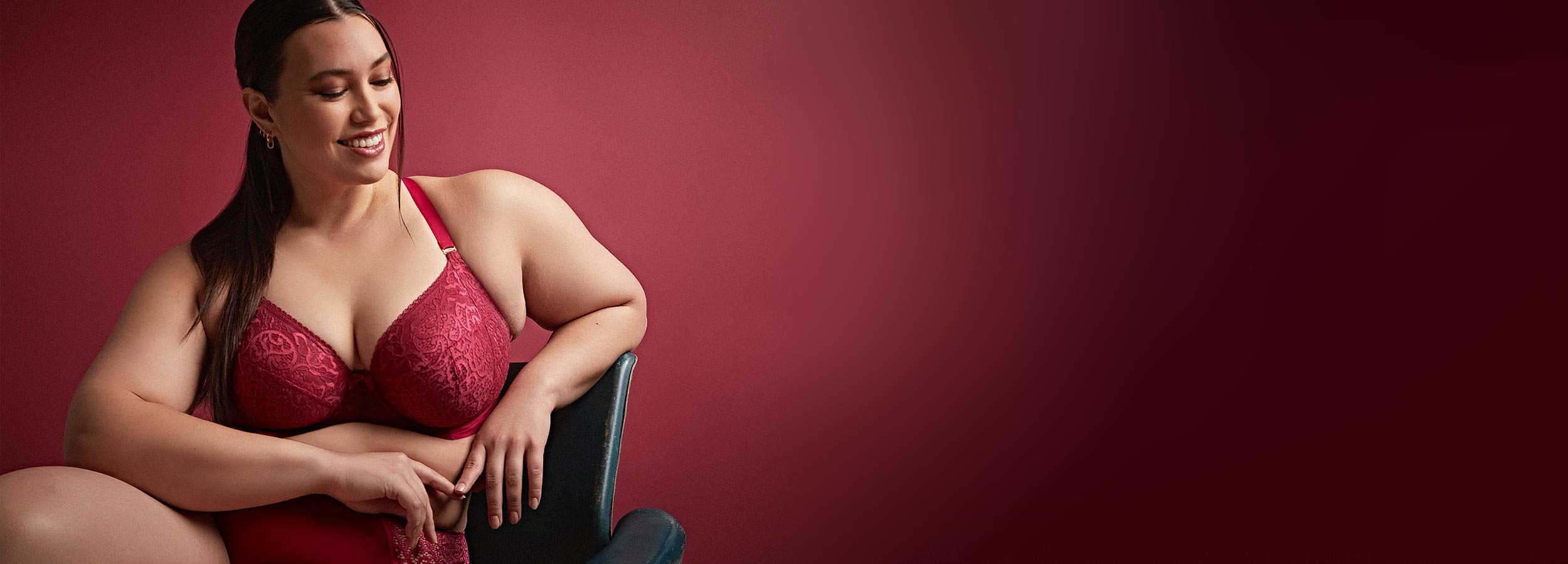Woman sitting on chair in red plus size lingerie