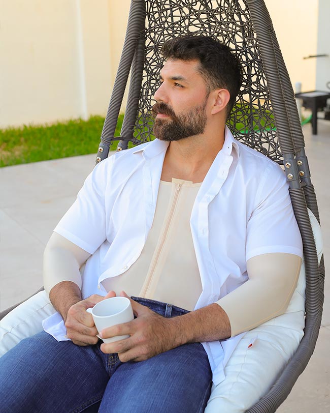 Man in compression garment and shirt holding mug