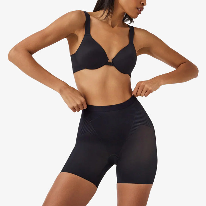 Black shaping shorts and bra set on a model against a white background