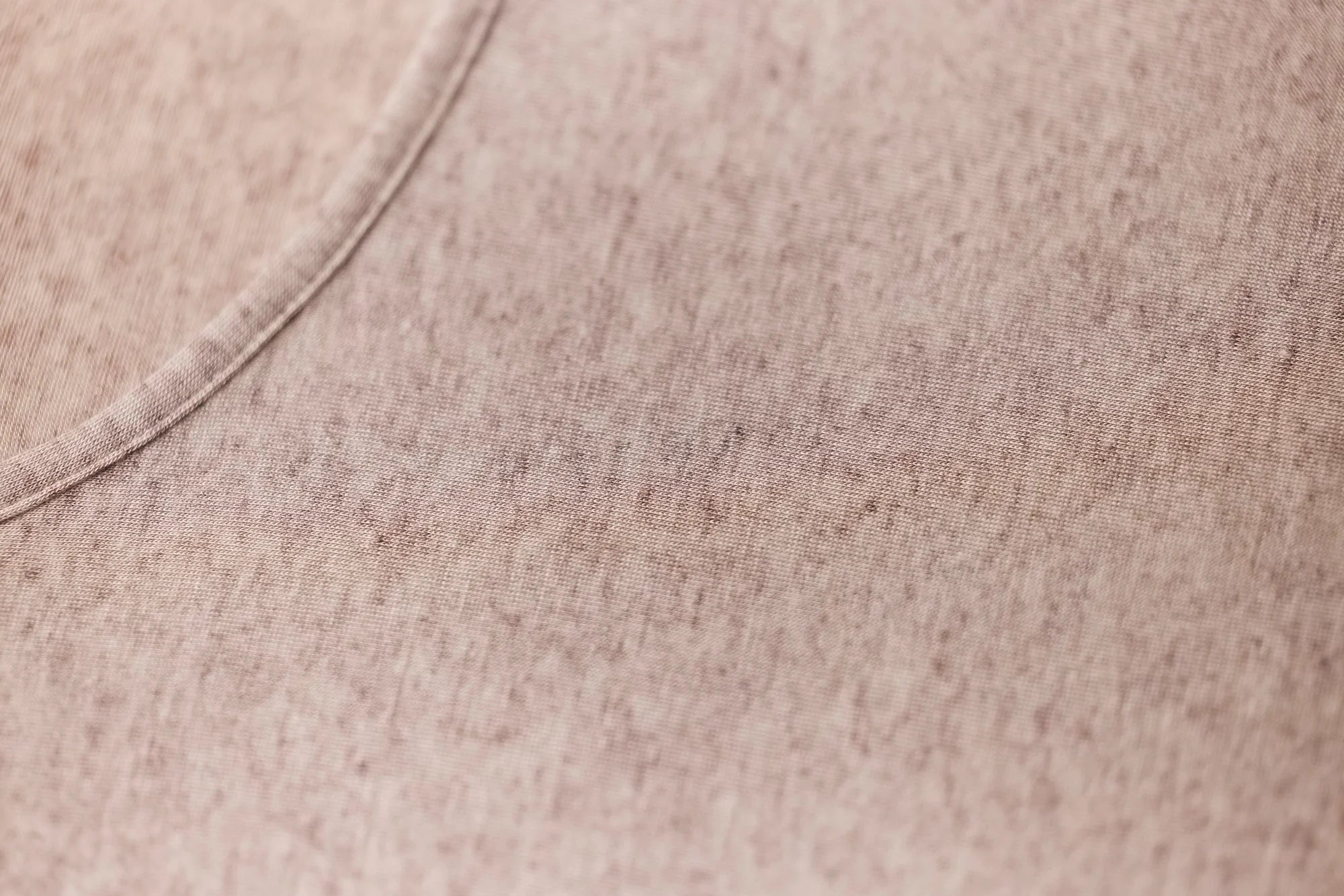 Beige heathered cotton fabric with curved seam on modal cashmere tank top showing texture and detail