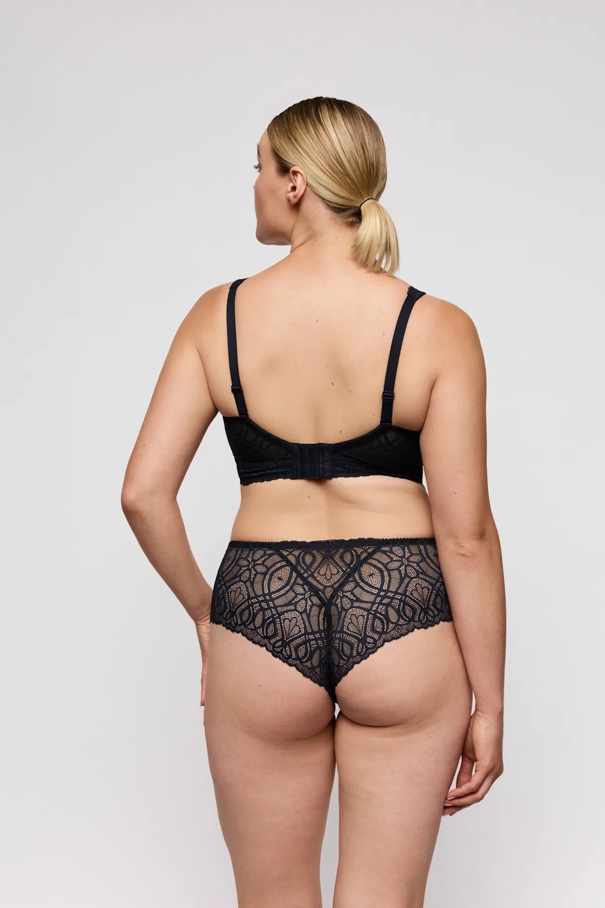Salerno full cup bra in black lace with intricate circular patterns and seamless design front view