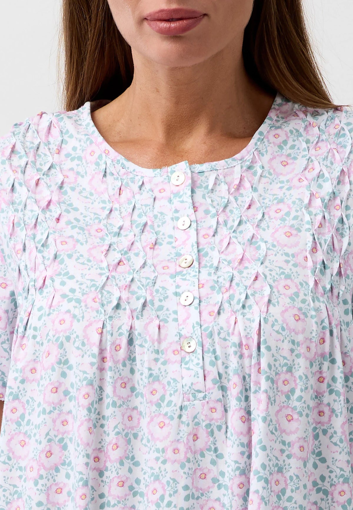 A soft light blue and pink floral print camellia short sleeve nightie with delicate smocking around the neckline
