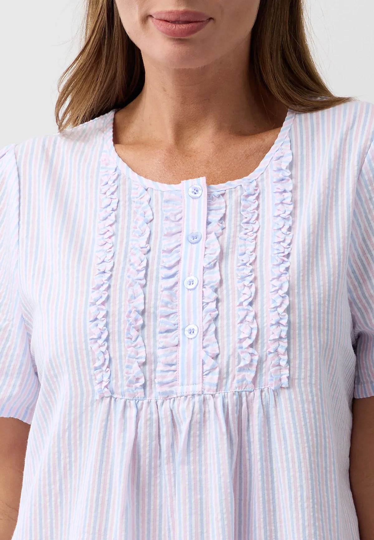 A soft light blue and white striped nightie with delicate ruffled detailing along the front placket