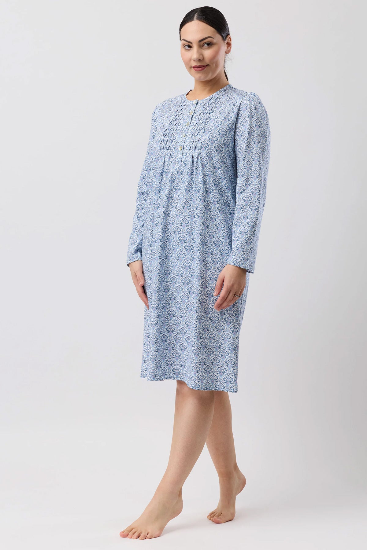 A light blue oriental smock nightie with a delicate white geometric pattern and subtle smocking at the neckline